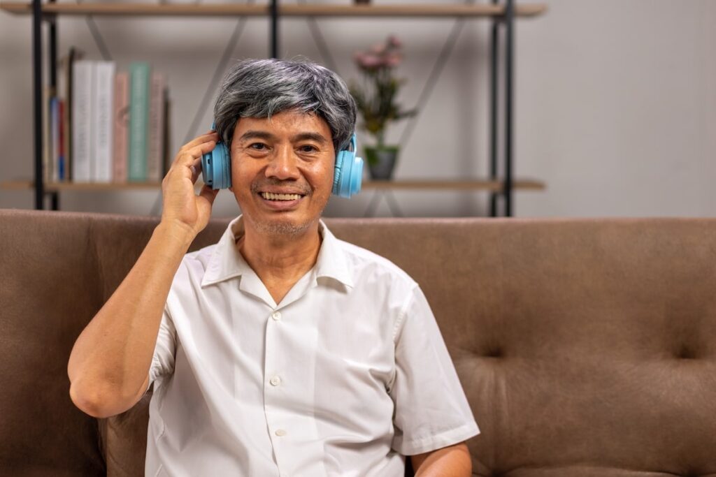 A smiling older adult with headphones