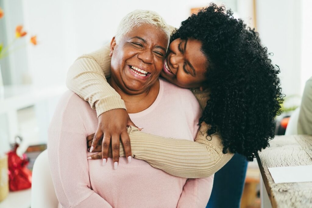 Adult daughter and her joyful mother having a sweet moment