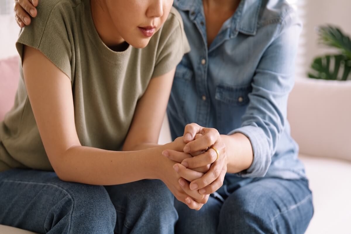 Young woman feeling anxious and getting comforted
