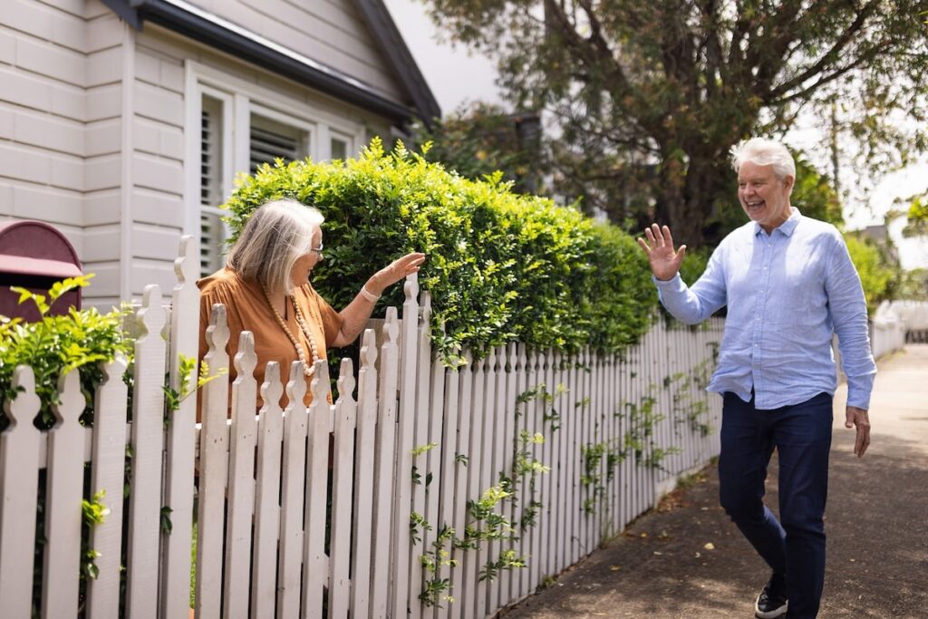 two neighbors wave good morning